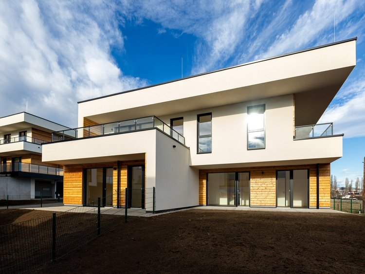 Neubau mit heller Fassade, Holzelementen und Garten