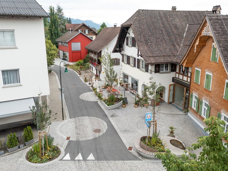 Vogelperspektive auf Dorfstraße mit traditionellen Mehrfamilienhäusern
