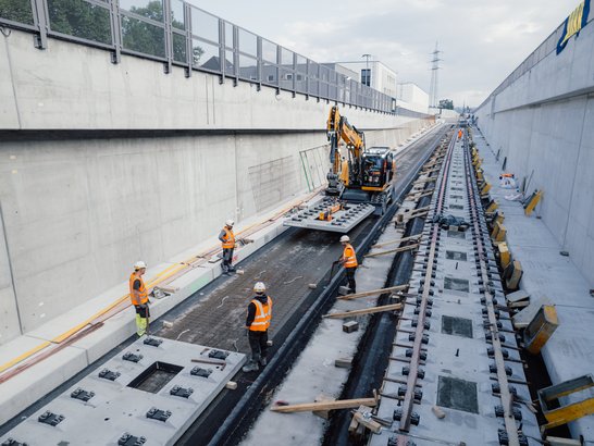 Mehrere Bauarbeiter auf einer Schienenbaustelle in der Stadt