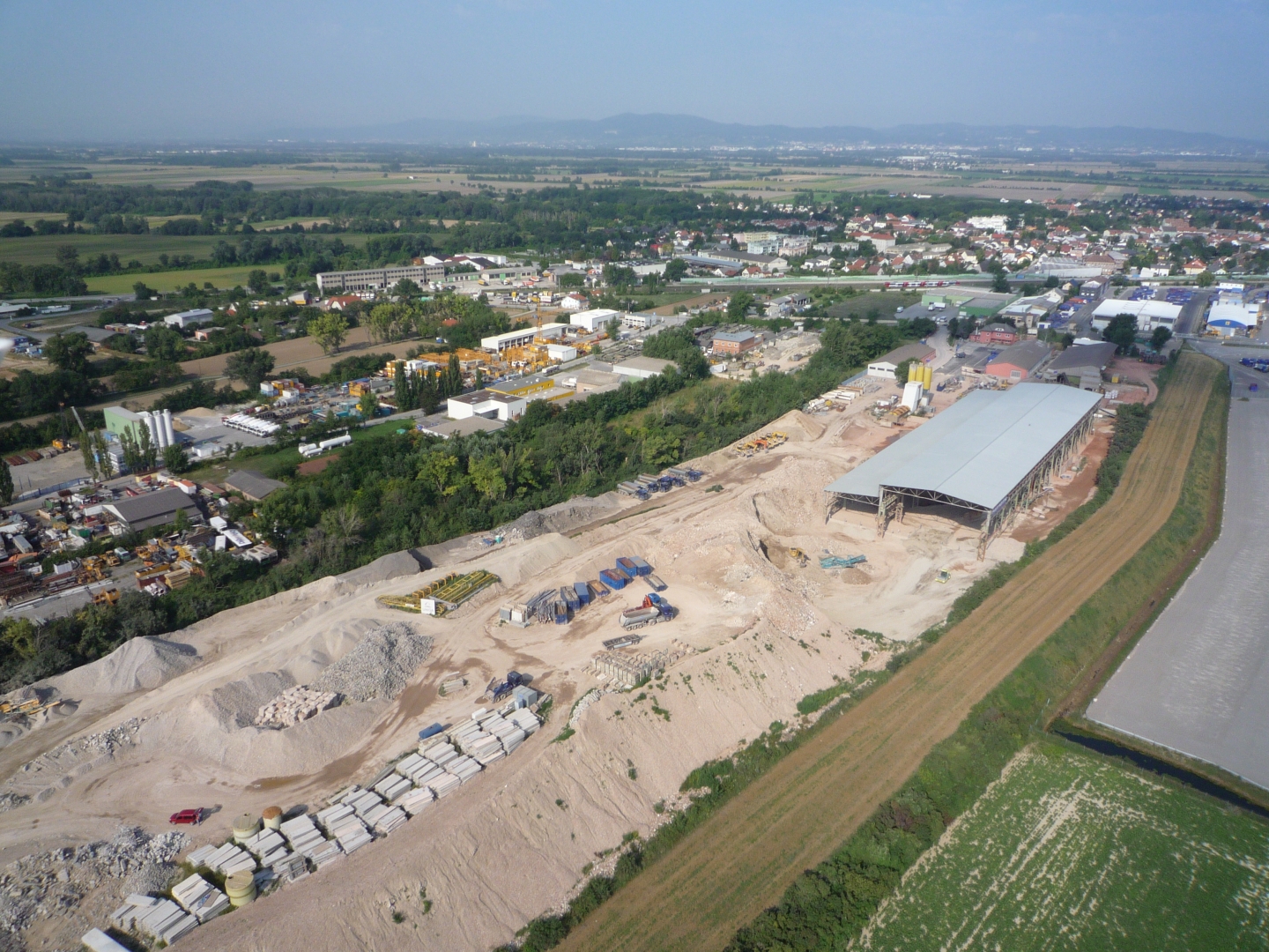 Photo: Recycling plant Himberg: Aerial shot of the vast construction facilities with halls and storage areas for residual construction waste sorted by grades.